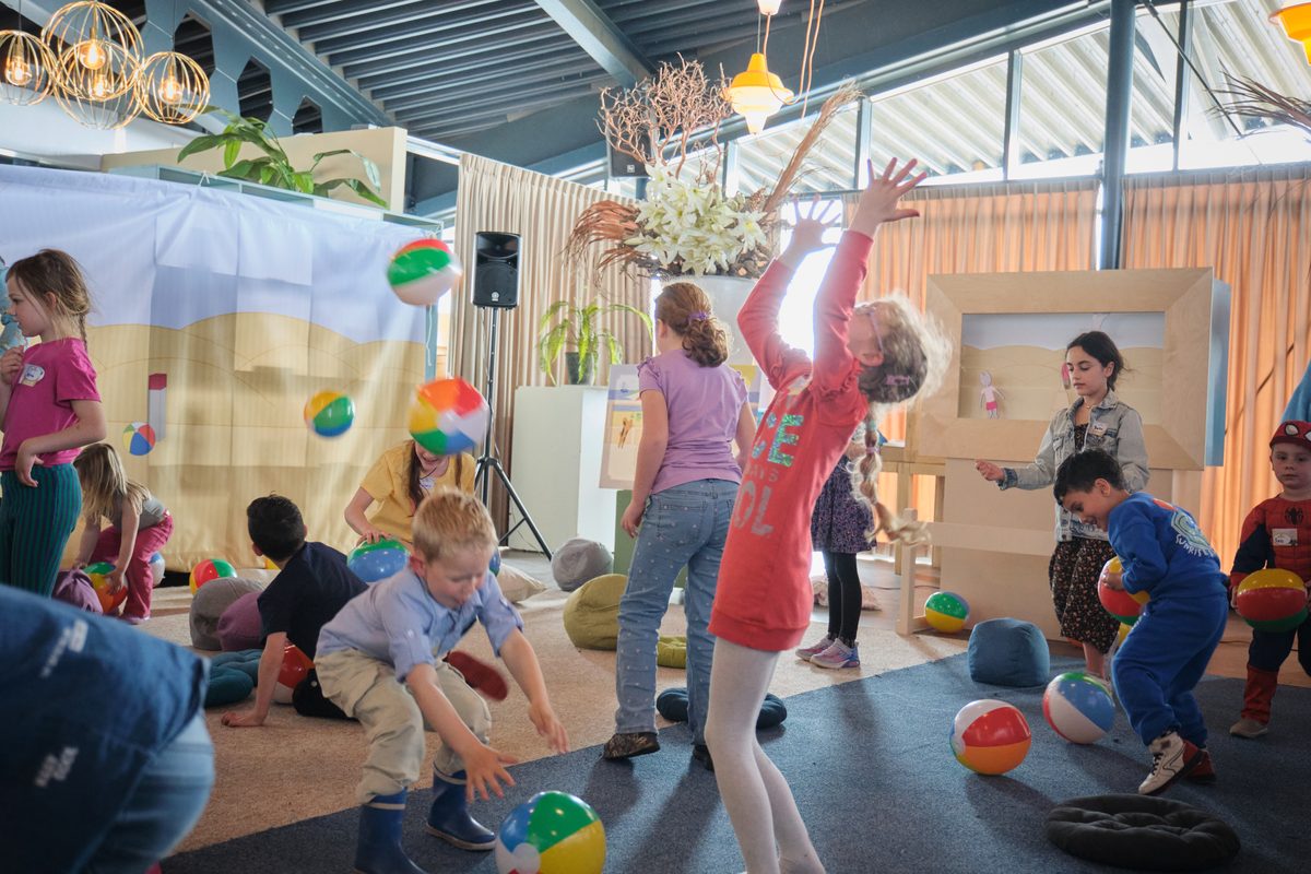 Kinderen spelen met strandballen in de zaal